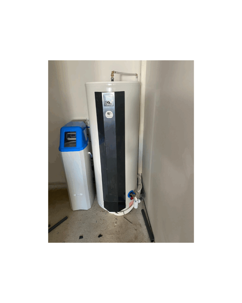 Chauffe-eau thermodynamique et adoucisseur d'eau Chauffe-eau thermodynamique blanc et noir avec affichage digital, à côté d'un adoucisseur d'eau bleu et blanc dans une pièce de service.