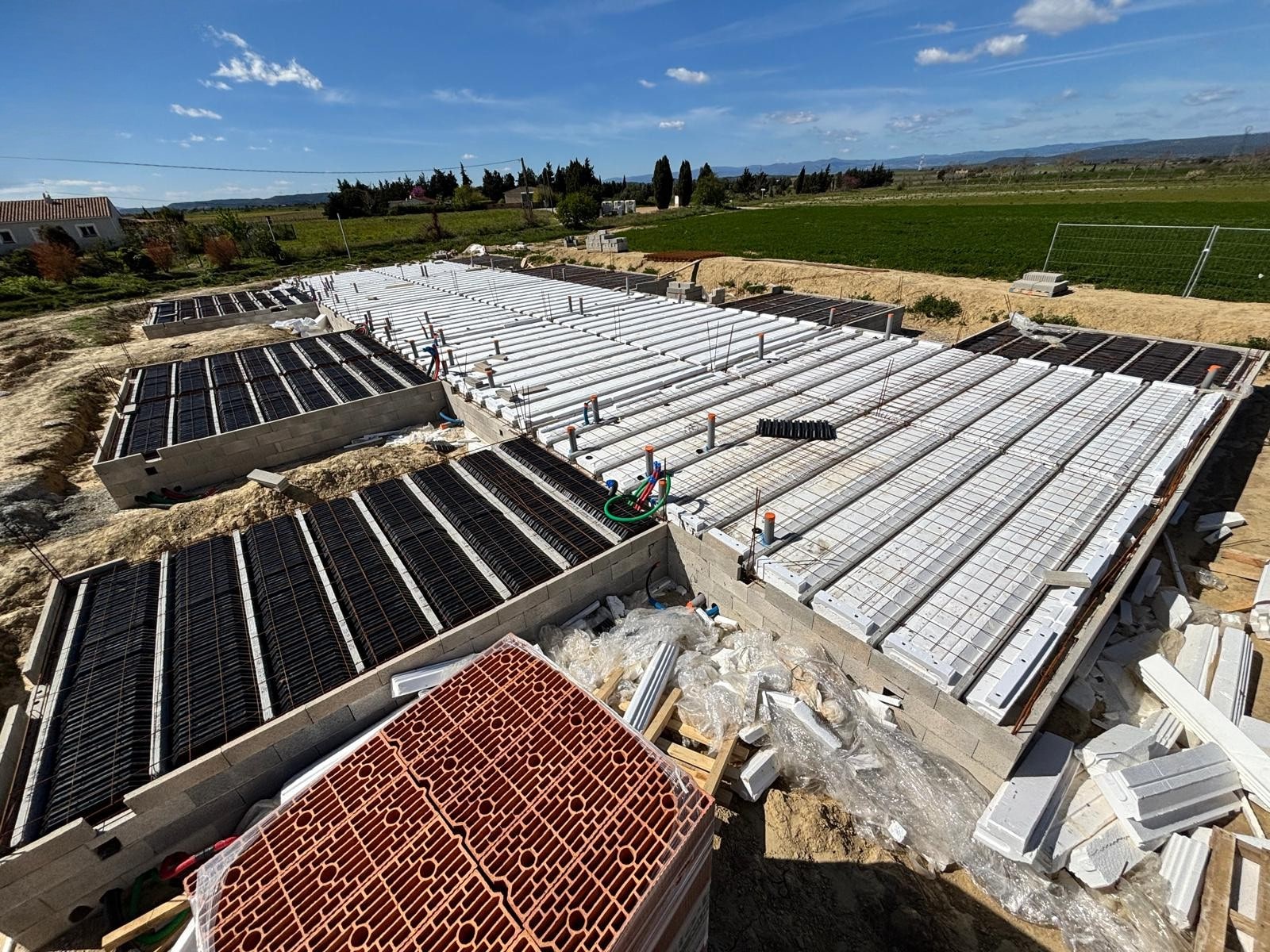 Installation d’un Plancher Hourdis sur Vide Sanitaire Chantier de construction avec pose de poutrelles et entrevous pour la réalisation d'un plancher sur vide sanitaire.